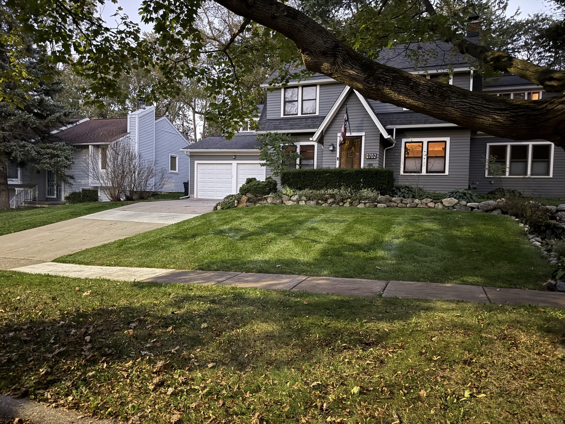 A freshly cut lawn in autumn with fallen leaves scattered along the edges
